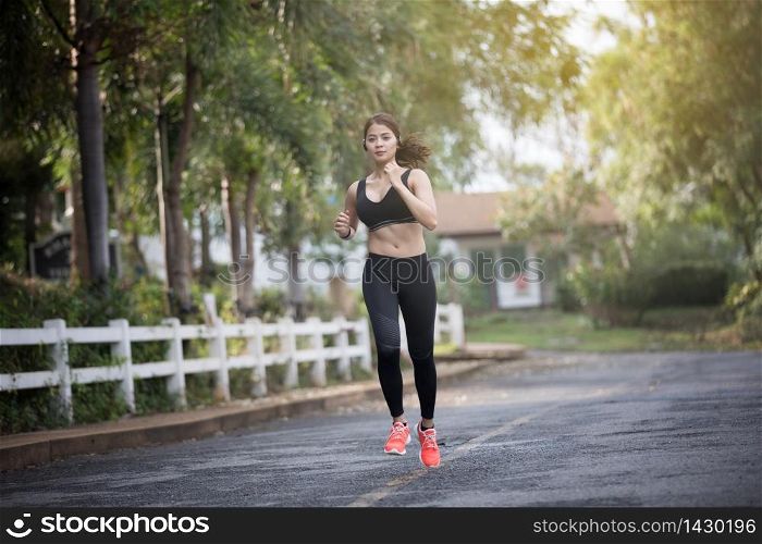 Running woman. Female runner jogging during outdoor on road .Young mixed race girl jogging