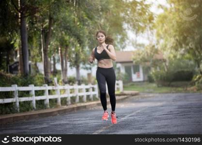 Running woman. Female runner jogging during outdoor on road .Young mixed race girl jogging
