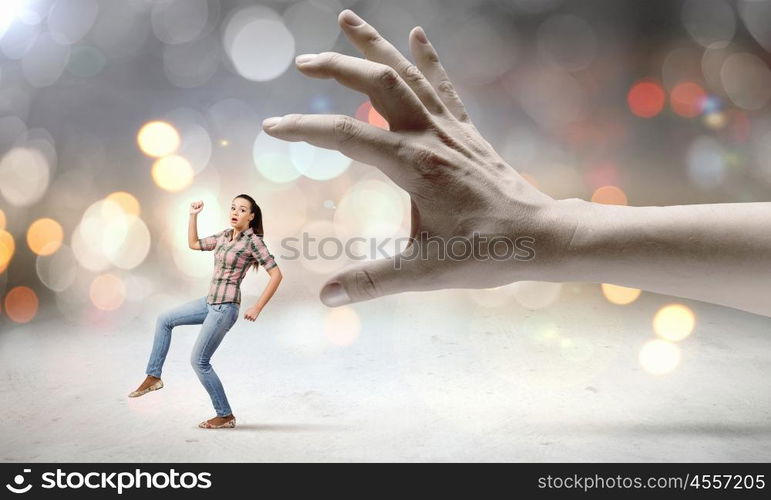 Running woman. Young woman in casual escaping from big male hand