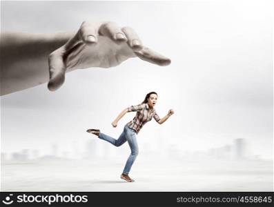 Running woman. Young woman in casual escaping from big male hand