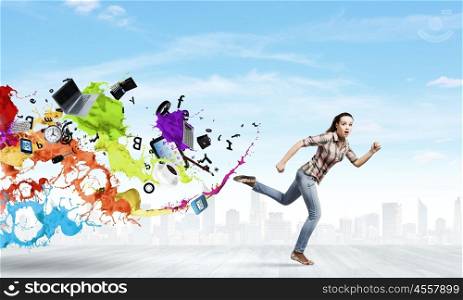 Running woman. Young woman in casual escaping from colorful splashes