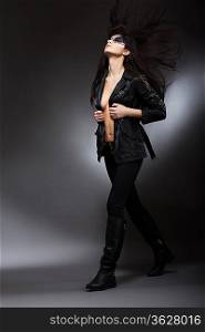 Runway Fashion Model walking on Podium in Black Trendy Garments. Elegance
