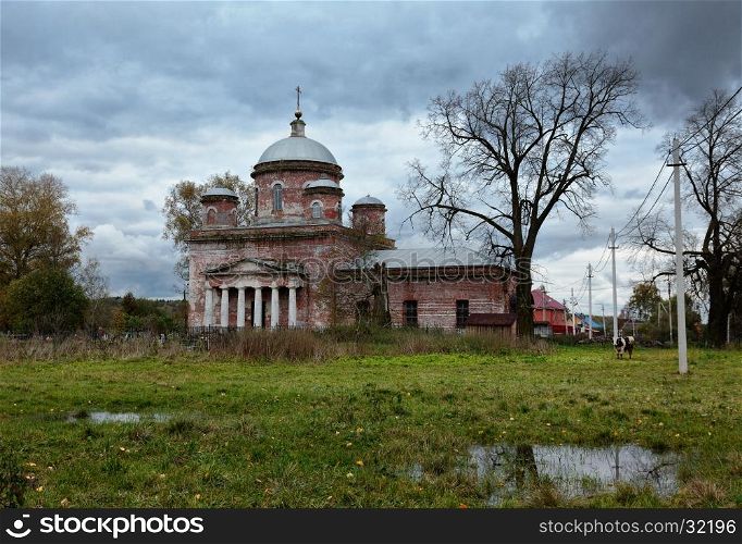 Rural autumn landscape with old abandoned church and overcast sky