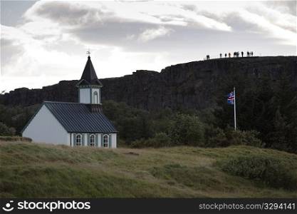 Rural church and flagpole next to hillside