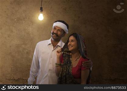 Rural couple looking at light bulb in house
