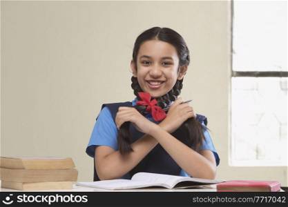 Rural girl in school uniform playing with her hair while studying