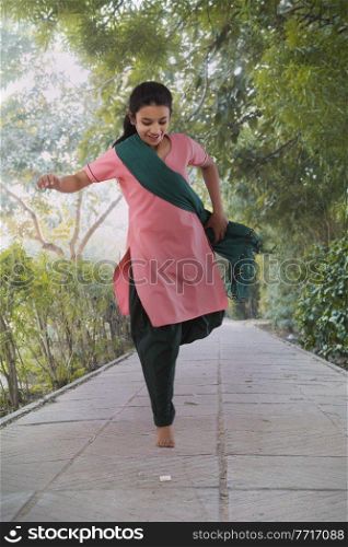 Rural girl playing hopping game in park