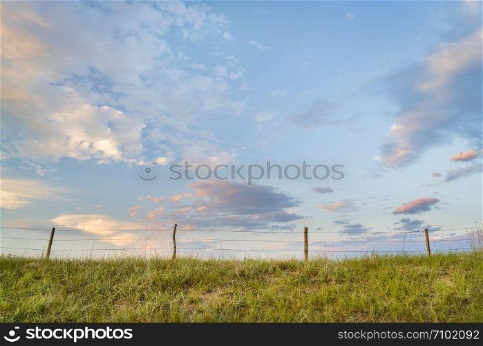 rural landscape of Nebraska Sandhills with a cattle fence