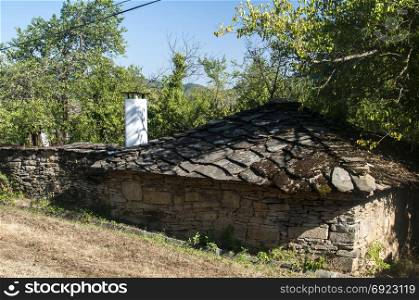 Rural landscape with old stone country house with stone slabs roof