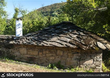 Rural landscape with old stone country house with stone slabs roof