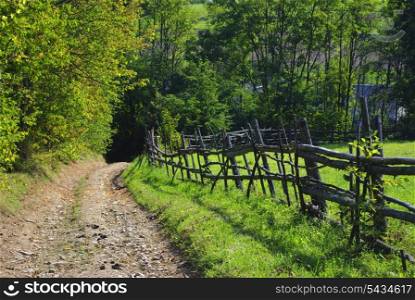 Rural landscape with road and wooden fence