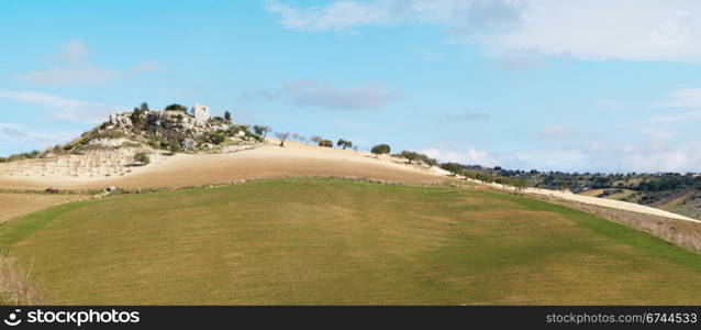 Rural landscape with ruin of farmhouse on the hill