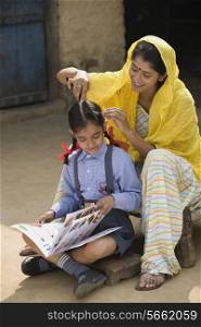 Rural mother straightens her daughters h