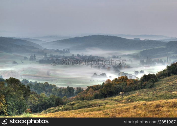 Rural mountain village in fog aerial view, Kalnik mountain, Croatia