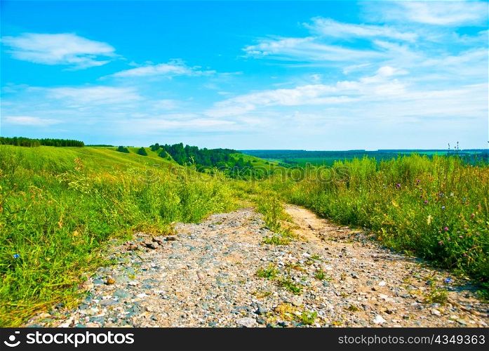 Rural road,blue sky and green grass
