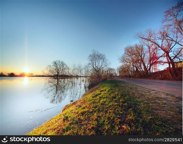 Rural road on sunrise. Road near water. Hight water at Oka river in Russia