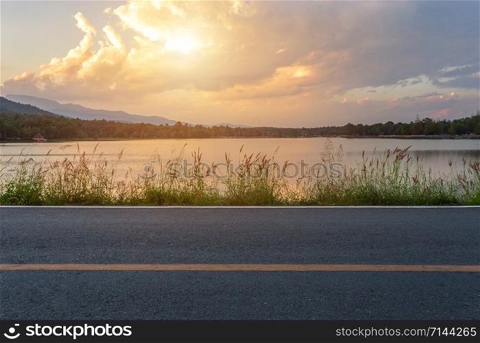 Rural road with Scenic view of the reservoir Huay Tueng Tao with Mountain range forest at evening sunset in Chiang Mai, Thailand