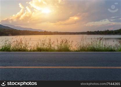 Rural road with Scenic view of the reservoir Huay Tueng Tao with Mountain range forest at evening sunset in Chiang Mai, Thailand