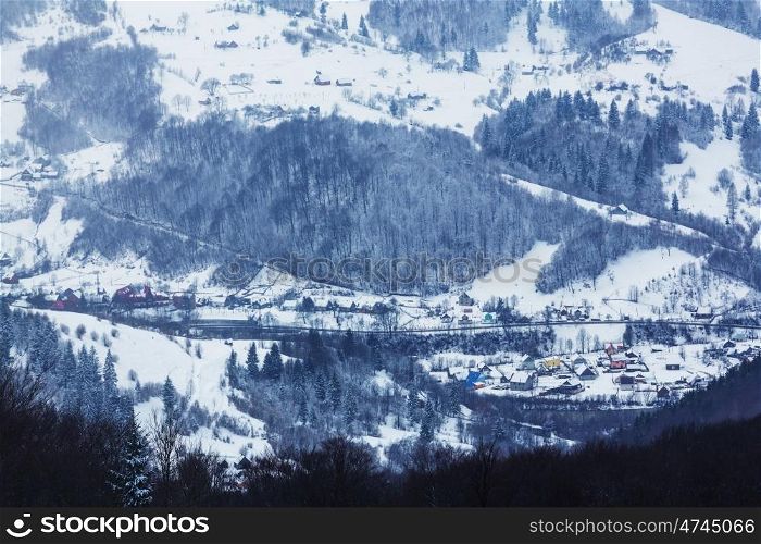 Rural scene in Carpathian mountains in winter season. Misty weather.