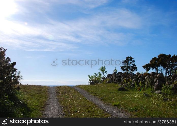 Rural tracks at blue sky by a stonewall