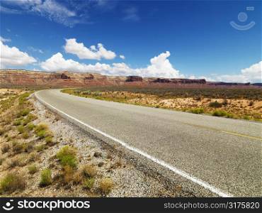 Rural Utah scenic road with mountain range in distance.