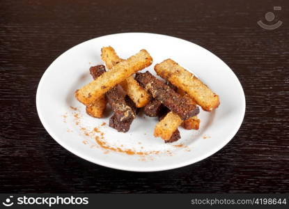 Rusk with garlic on a plate at wooden background