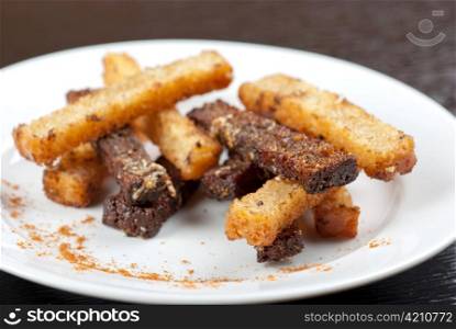 Rusk with garlic on a plate at wooden background
