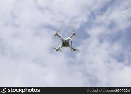 Russia, Poltavskaya village - May 1, 2016  Flying white quadrocopters DJI Phantom 4 over a field of wheat. Flying gadget for video.. Flight quadrocopters white against the blue sky with clouds
