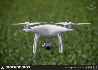 Russia, Poltavskaya village - May 1, 2016  Flying white quadrocopters DJI Phantom 4 over a field of wheat. Flying gadget for video.. Flying white quadrocopters over a field of wheat