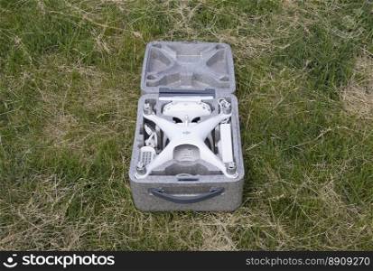 Russia, Poltavskaya village - May 13, 2016  Open case with quadrocopters DJI Phantom 4. The opening of the box on the lawn.. Open case with quadrocopters DJI Phantom 4