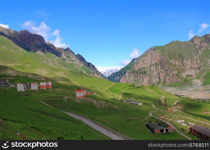 Russian Caucasus green mountains with old ruined houses