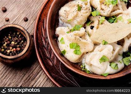 Russian meat dumplings pelmeni on wooden rustic background.Russian pelmeni. Ukrainian pelmeni on plate
