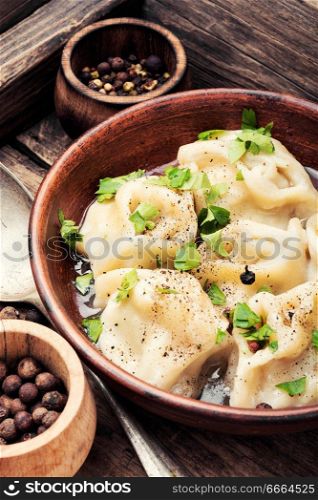Russian meat dumplings pelmeni on wooden rustic background.Russian pelmeni. Ukrainian pelmeni on plate