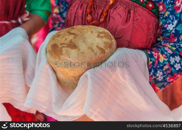 Russian old-fashioned wedding. Hands with bread, meeting with guests