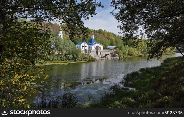 Russian Orthodox Church on the shore of a pond in autumn