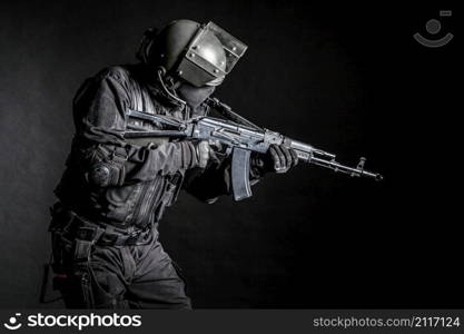 Russian special forces operator in black uniform and bulletproof helmet. Russian special forces