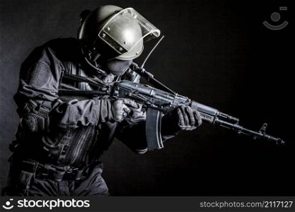 Russian special forces operator in black uniform and bulletproof helmet. Russian special forces operator