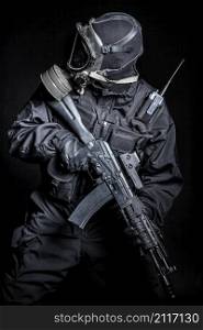 Russian special forces operator in black uniform and gas mask. Russian special forces