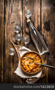 Russian style. Vodka with pickled mushrooms. On wooden background.. Russian style. Vodka with pickled mushrooms.