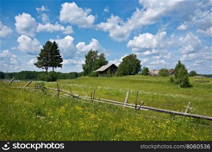 Russian summer meadow. Wooden fence. Arkhangelsk region, Russia