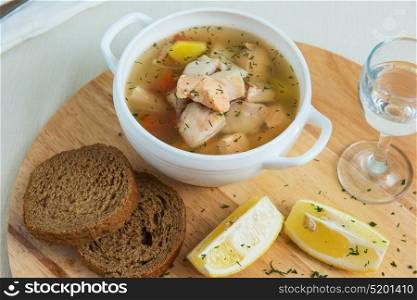 Russian traditional fish soup. Russian traditional fish soup - ukha, served with bread lemon tomato and vodka
