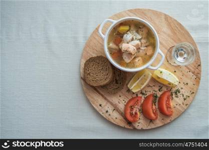 Russian traditional fish soup - ukha, served with bread lemon tomato and vodka