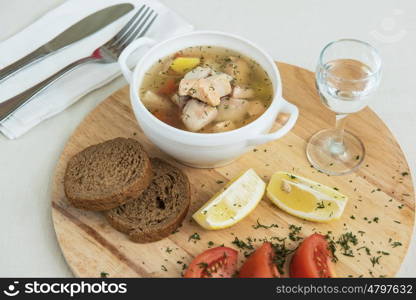 Russian traditional fish soup - ukha, served with bread lemon tomato and vodka