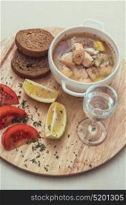 Russian traditional fish soup - ukha, served with bread lemon tomato and vodka. Russian traditional fish soup