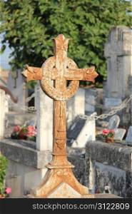 rusted, cast irons cross ornament with a wreath at an old cemetery in the Provence