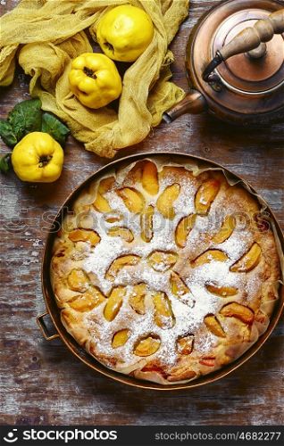 Rustic baked pie with quince. Homemade cake with quince and copper kettle.View top.