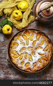 Rustic baked pie with quince. Homemade cake with quince and copper kettle.View top.