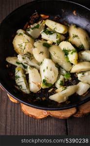 Rustic baked potato with herbs in frying pan