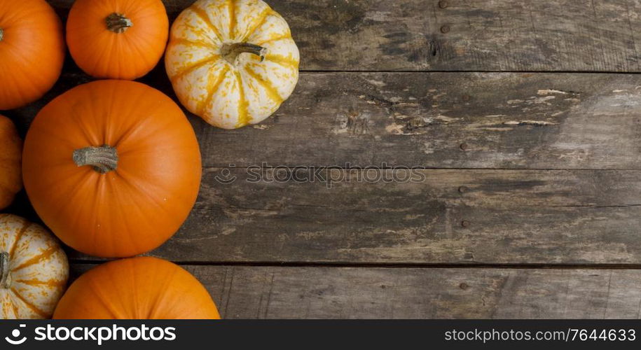 Rustic composition of pumpkins on wooden background with copy space for text, flat lay top view composition. Pumpkins on wooden background