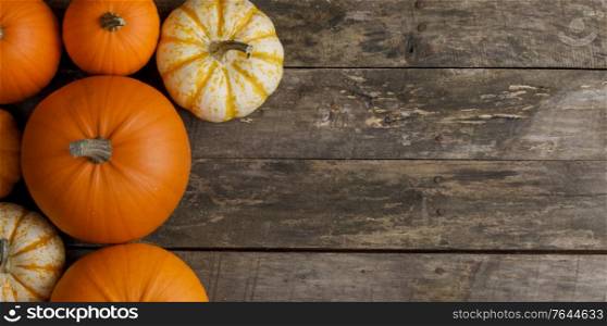 Rustic composition of pumpkins on wooden background with copy space for text, flat lay top view composition. Pumpkins on wooden background